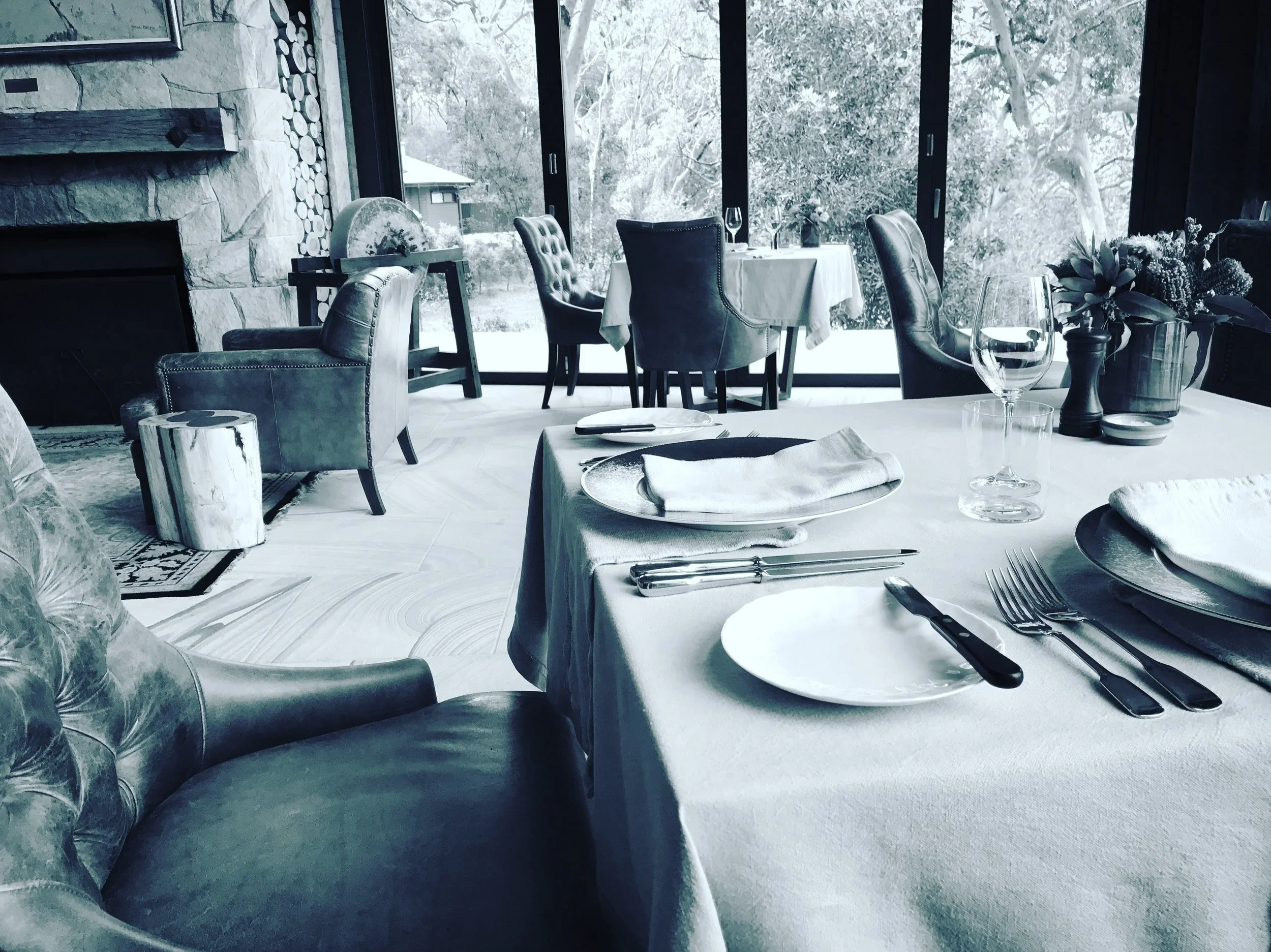 A restaurant table set for service beside the windows